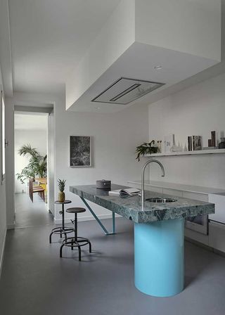 Kitchen, island counter with sink, breakfast overhang and stools. Extractor fan on low hanging roof section above island