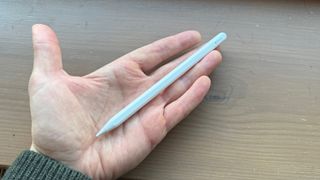 An open hand holding the Apple Pencil USB.