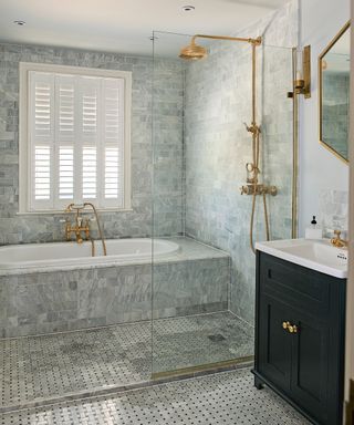 An example of shower tile ideas showing a bathroom with a walk-in shower and bathtub, covered in small grey marble tiles