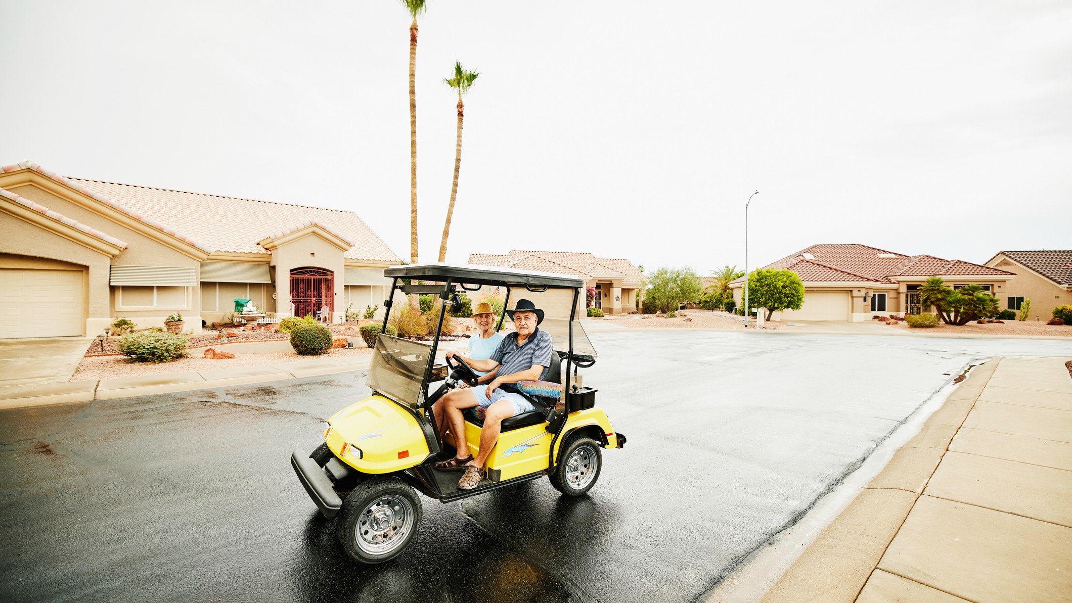 a man and his wife cruise the community in a golf cart
