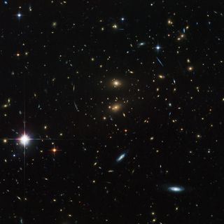 This Hubble Space Telescope image shows galaxy cluster LCDCS-0829. The huge mass of the galaxies in the cluster acts as a giant magnifying glass, in an effect called gravitational lensing.