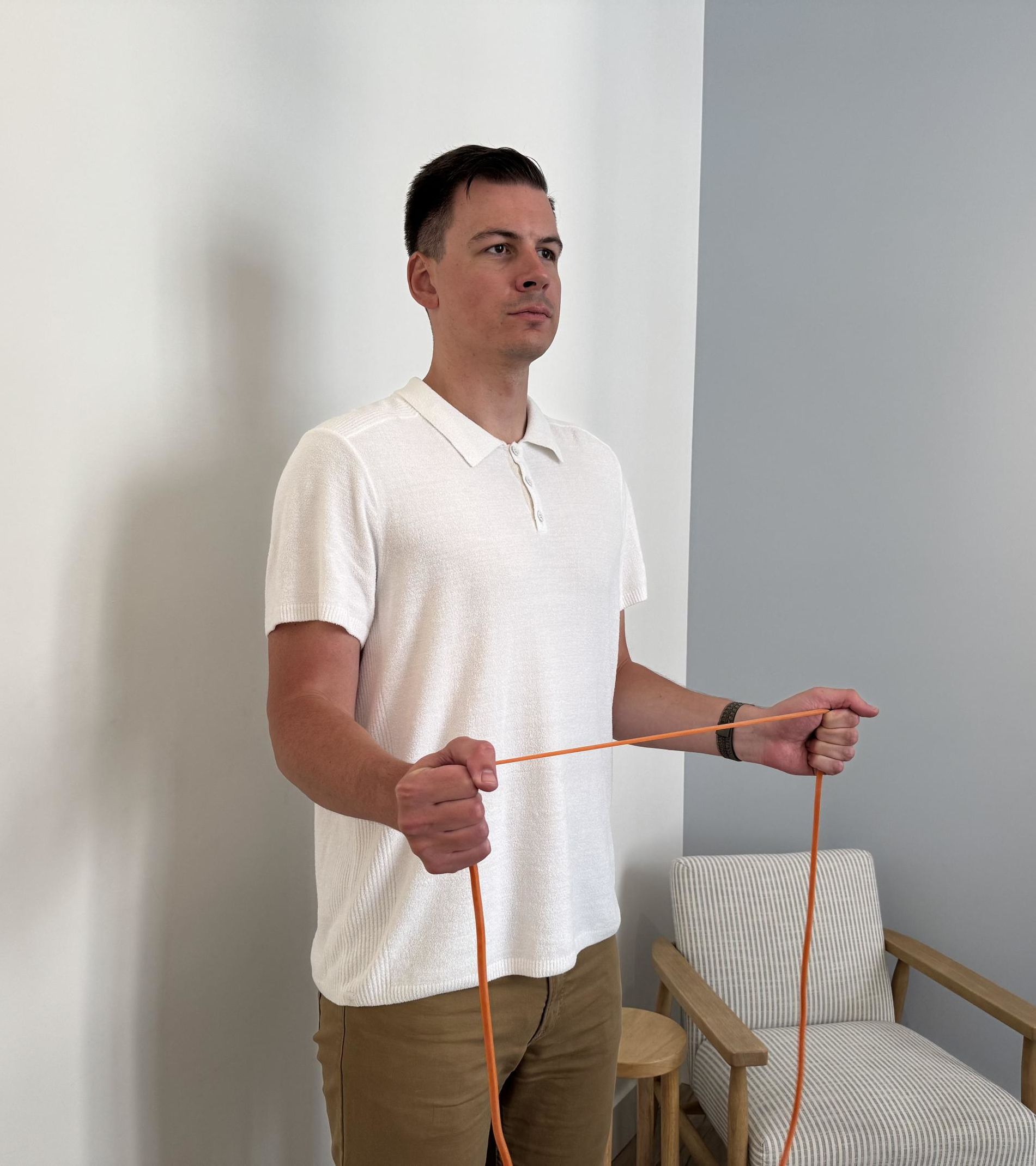 A man holding a thin orange resistance band