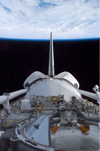 The space shuttle Discovery's cargo bay over Earth's horizon was photographed by one of the seven STS-114 crewmembers as the shuttle approached the International Space Station. Discovery's STS-114 mission was NASA's first return-to-flight mission followin