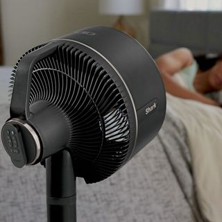 shark flexbreeze fan in a bedroom with a woman sleeping in background