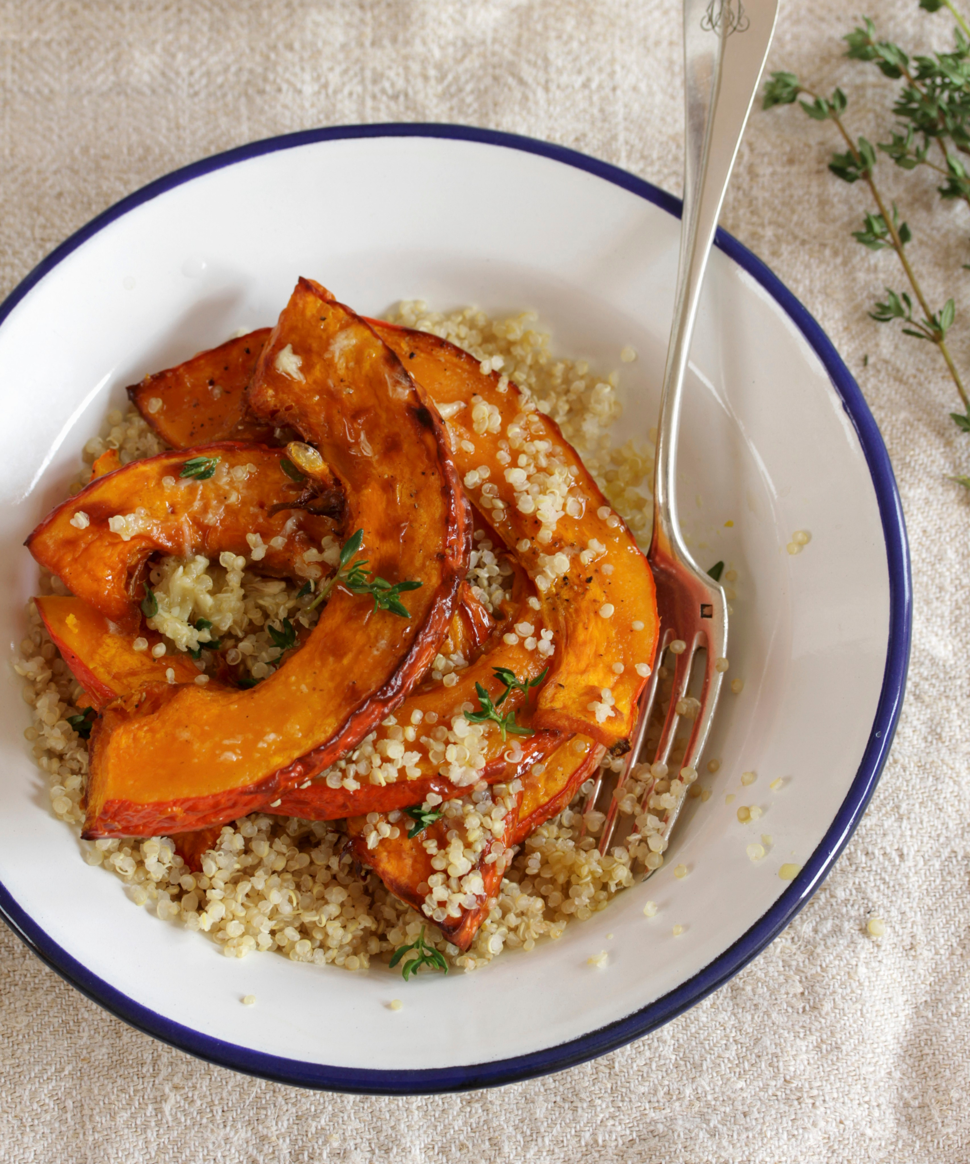 Roasted pumpkin and bulgar wheat salad in a white bowl on a linen tablecloth