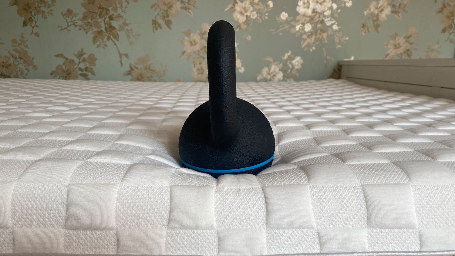 A kettlebell on the edge of the Levitex Gravity Defying Mattress