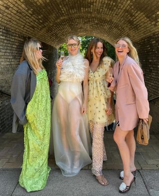 Scandinavian fashion influencers and creatives including Sidsel Alling pose at an outdoor wedding wearing a range of bright, fun, and chic wedding guest dresses.