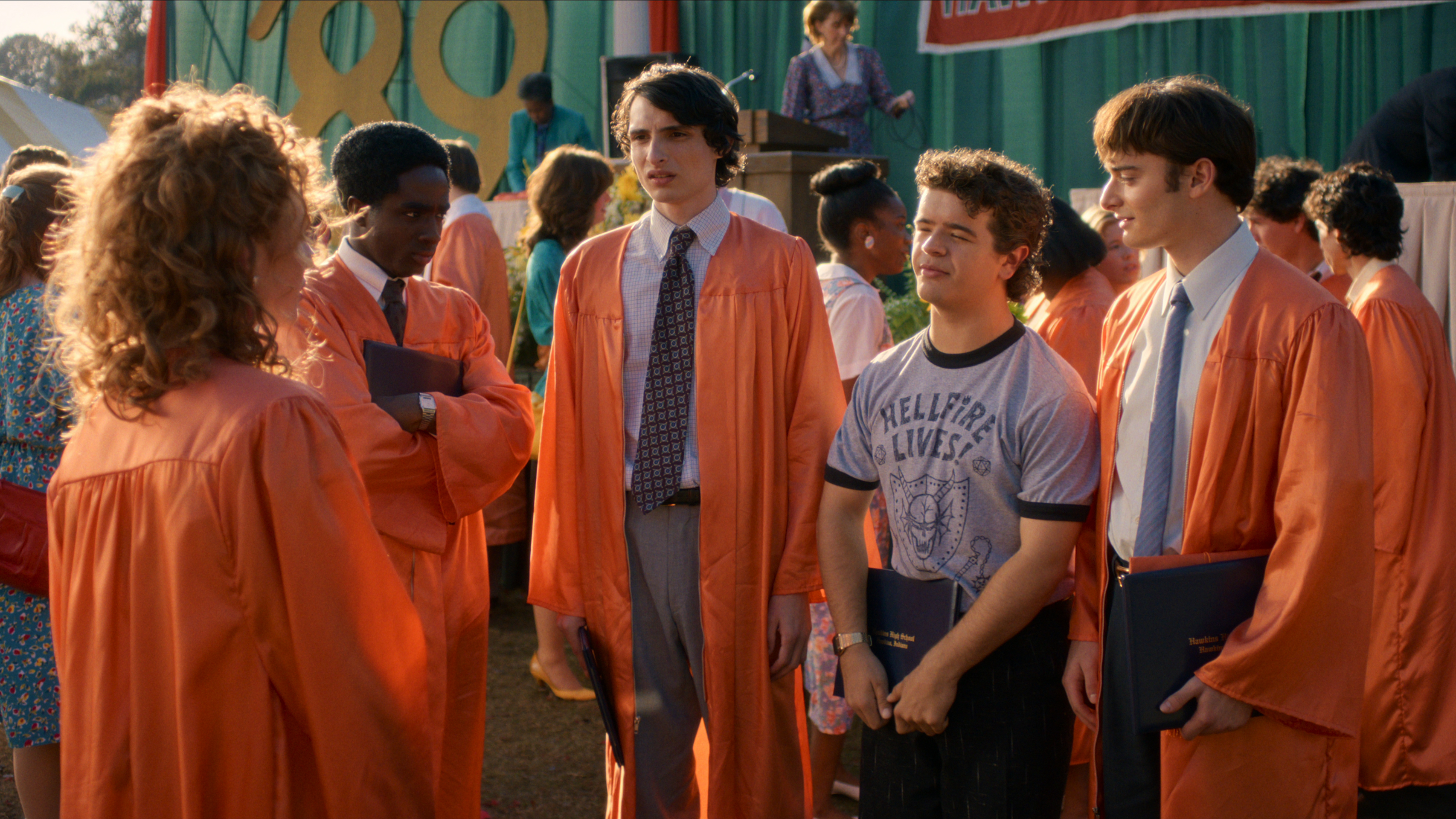 L-R: Lucas (Caleb McLaughlin), Mike (Finn Wolfhard), Dustin (Gaten Matarazzo), and Will (Noah Schnapp)in graduation attire in the "Stranger Things" season 5 finale