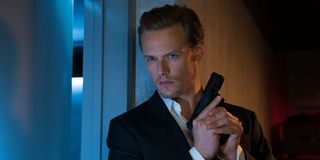 Sam Heughan sneaking around with a gun in The Spy Who Dumped Me.