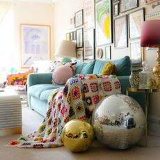 pale blue sofa in a living room with glitter balls by the side of it