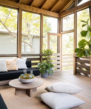 Wooden conservatory, black sofa, wooden table