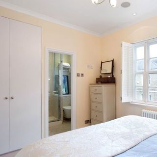 bedroom with white wardrobe with attached bathroom