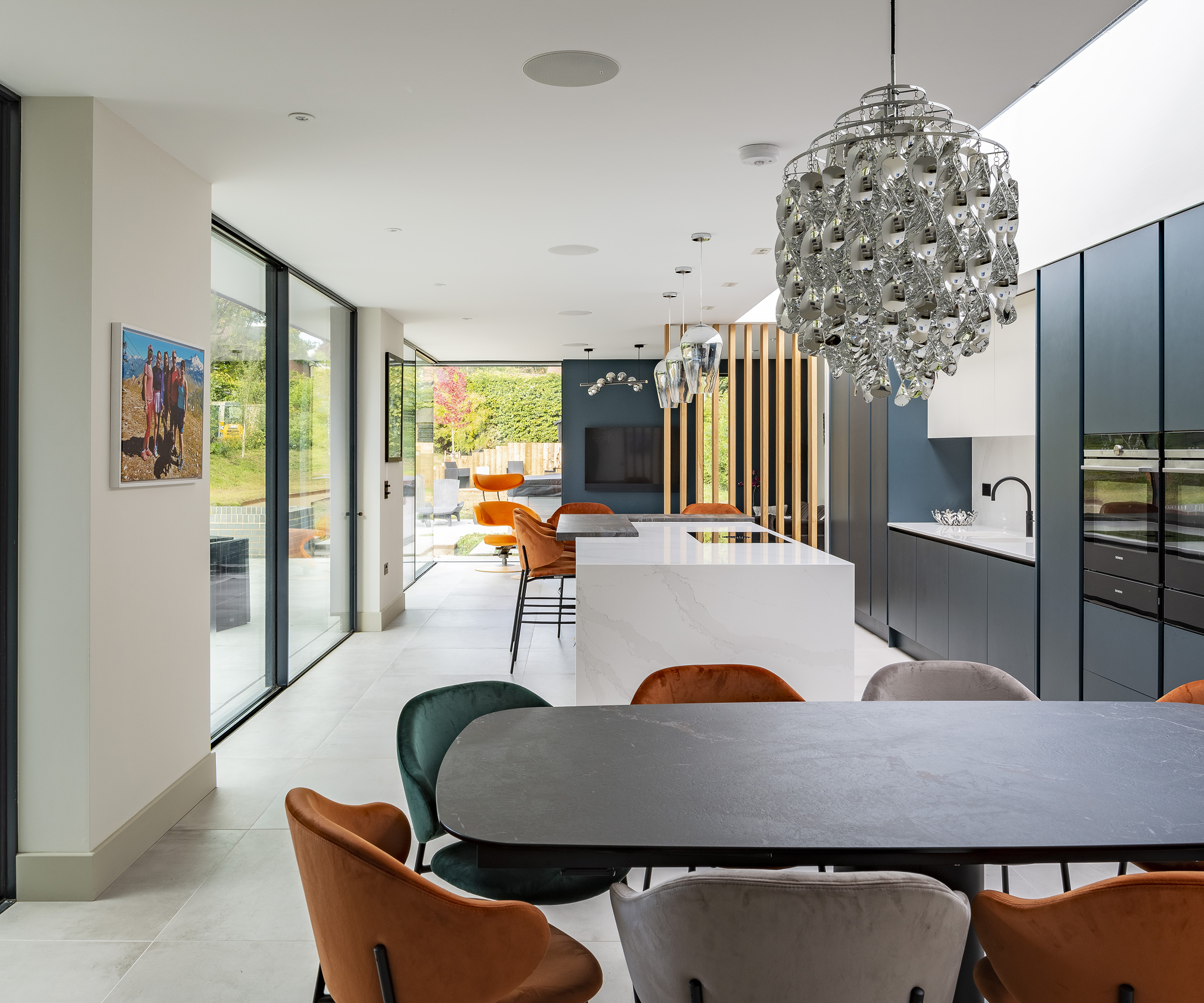 An open plan, kitchen and dining room in a modern kitchen extension with lots of glazed doors and roof glazing and contemporary interiors