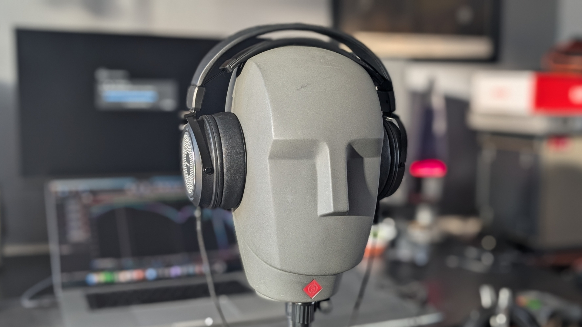 A pair of Behringer Alpha studio headphones on a Neumann KU 100 dummy head