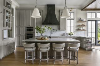 A kitchen island with lighting above it
