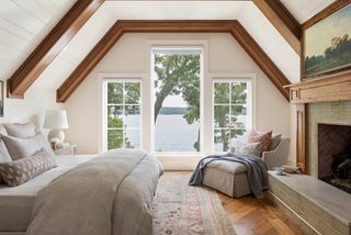 attic bedroom with wooden flooring and large windows