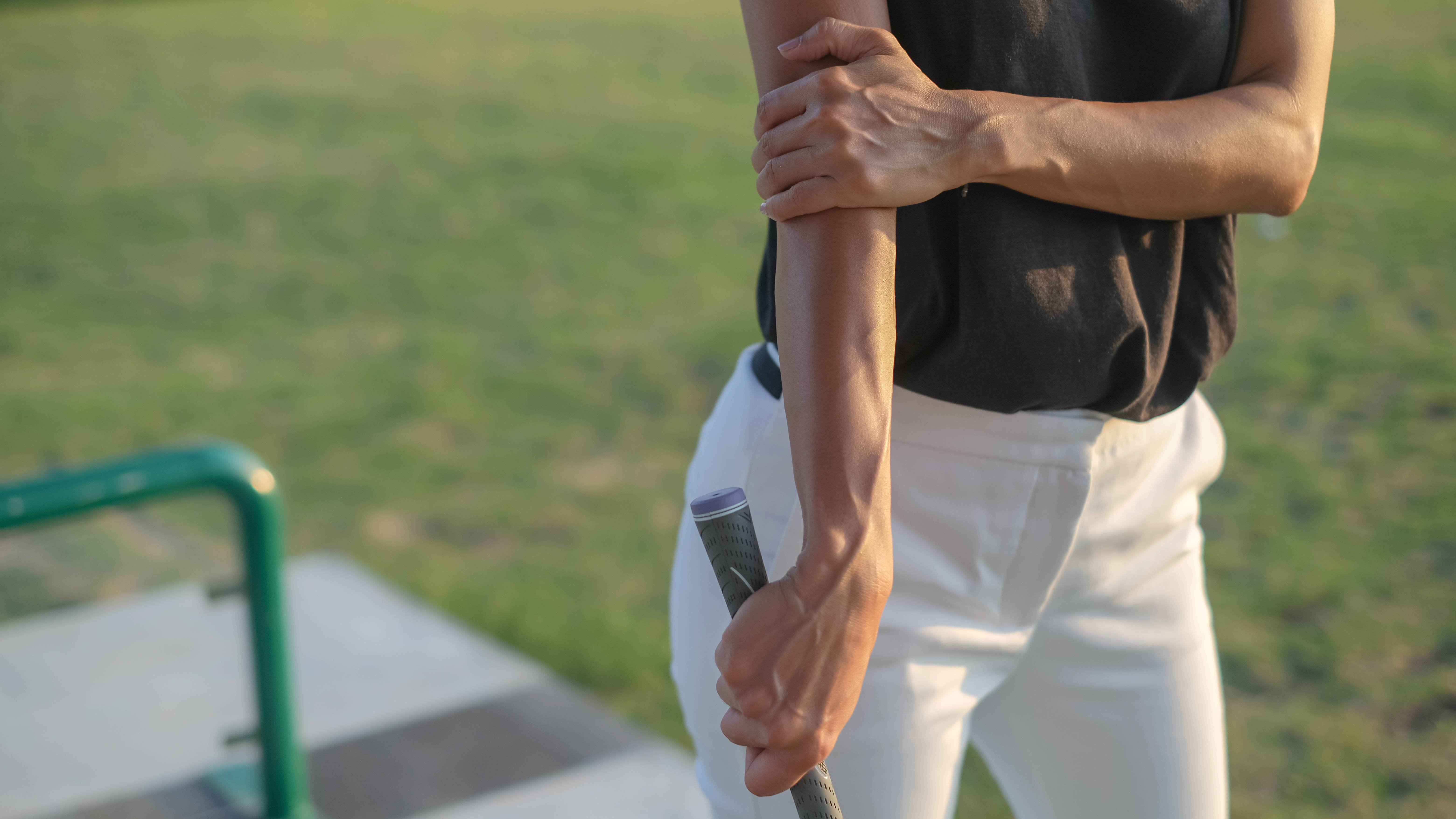 Golfer holding an injured elbow