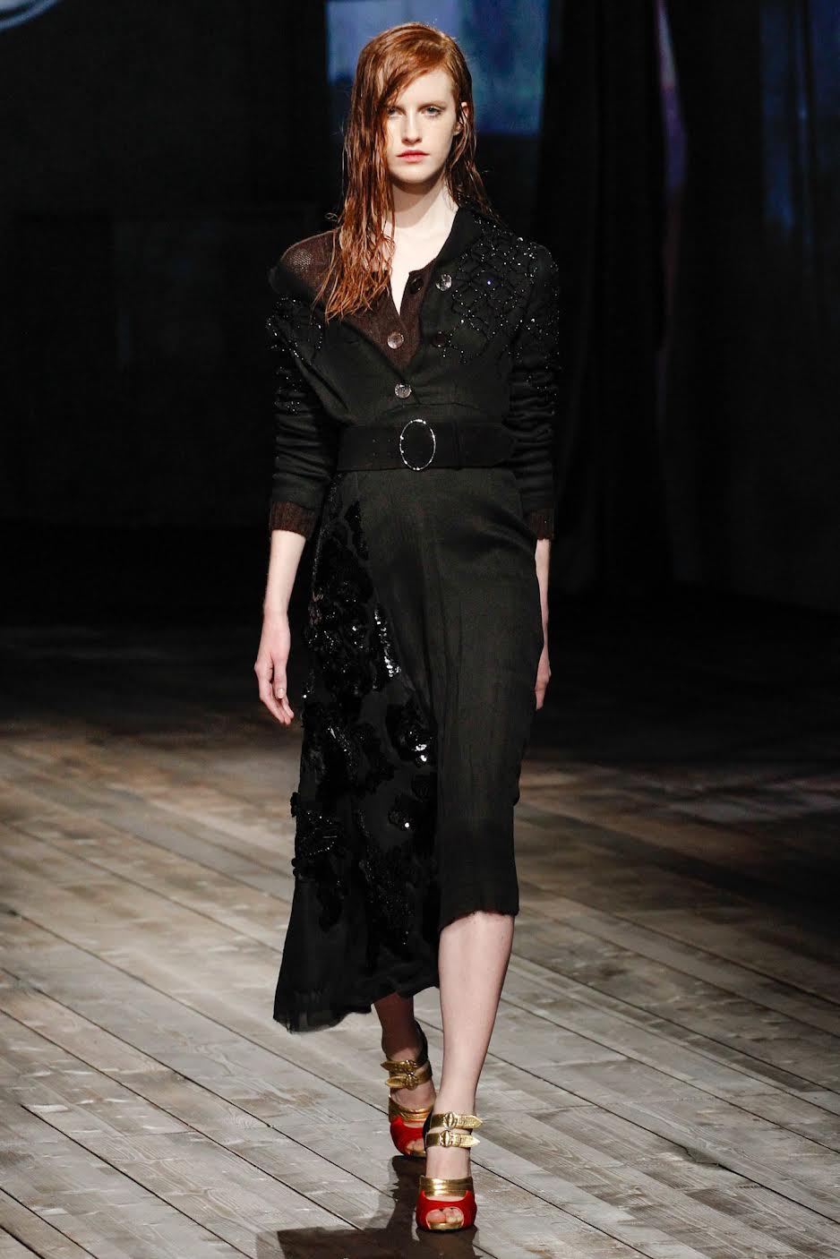 a model walking in the Prada Fall 2013 show wearing a black thin knit cardigan with a black skirt