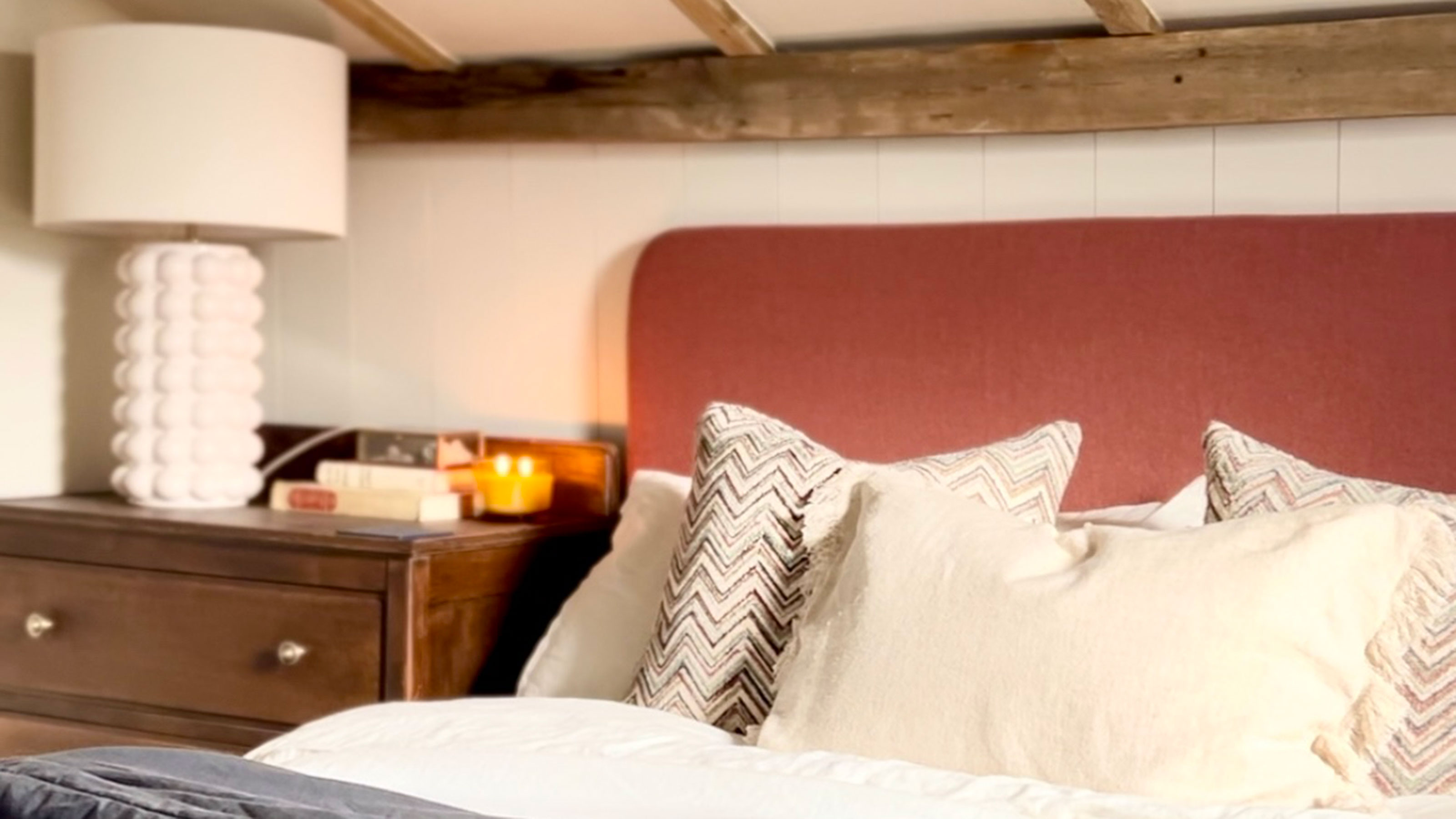 Bed under eaves ceiling with wooden beams