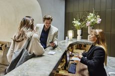 A couple checking in at hotel front desk during business trip 