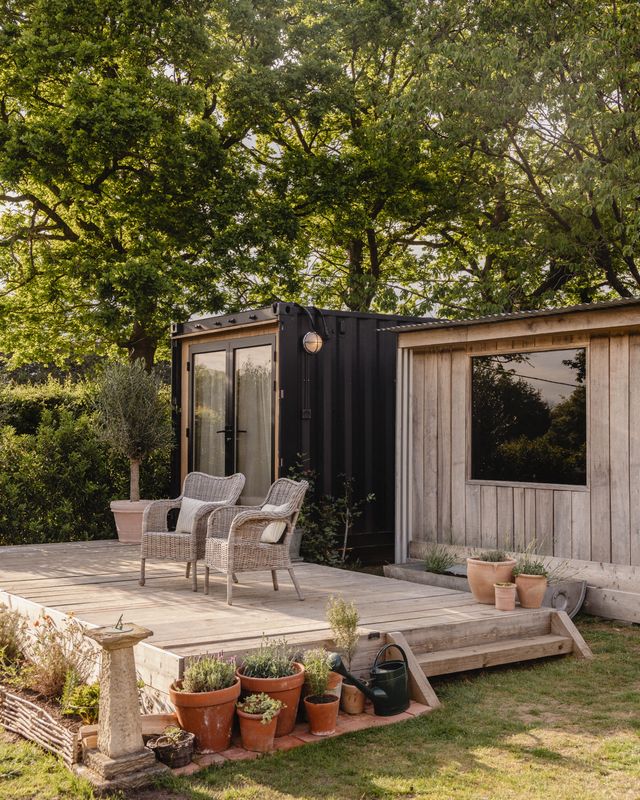 An cabin with glass doors and wooden patio.