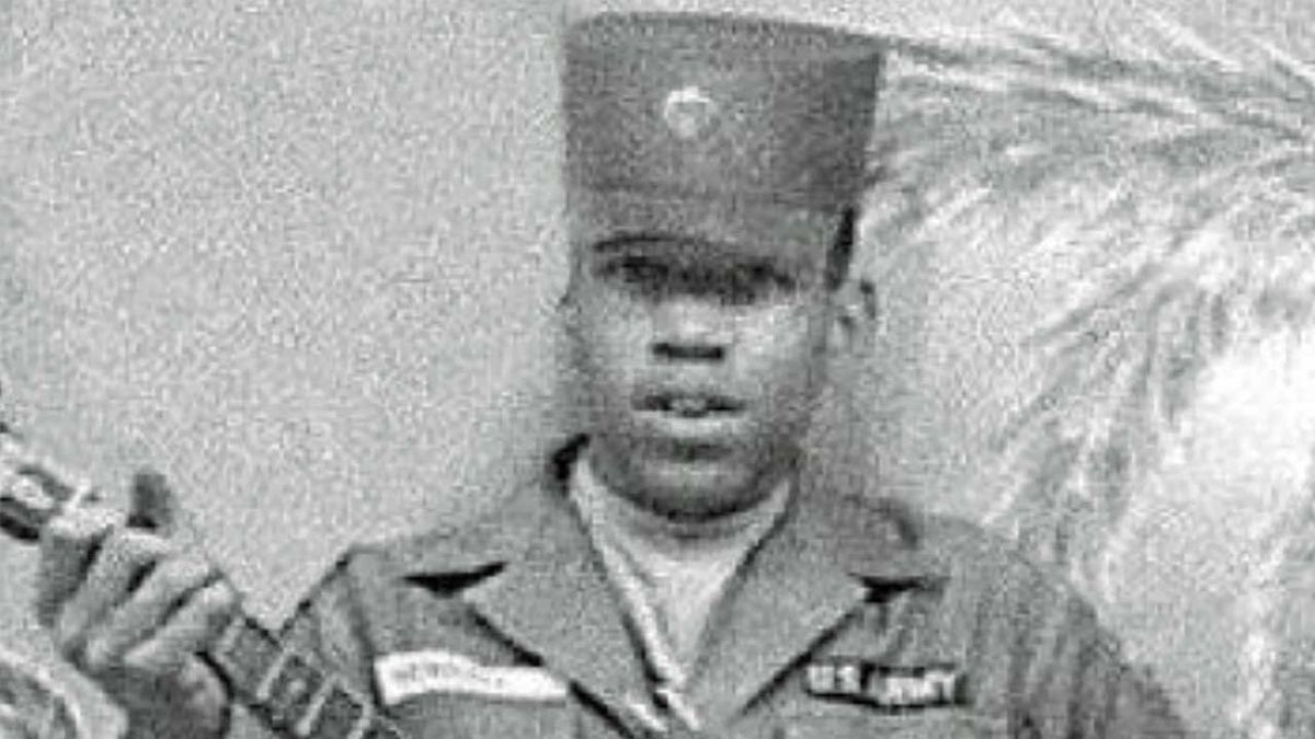 Jimi Hendrix in 1961 in his army uniform, holding a guitar