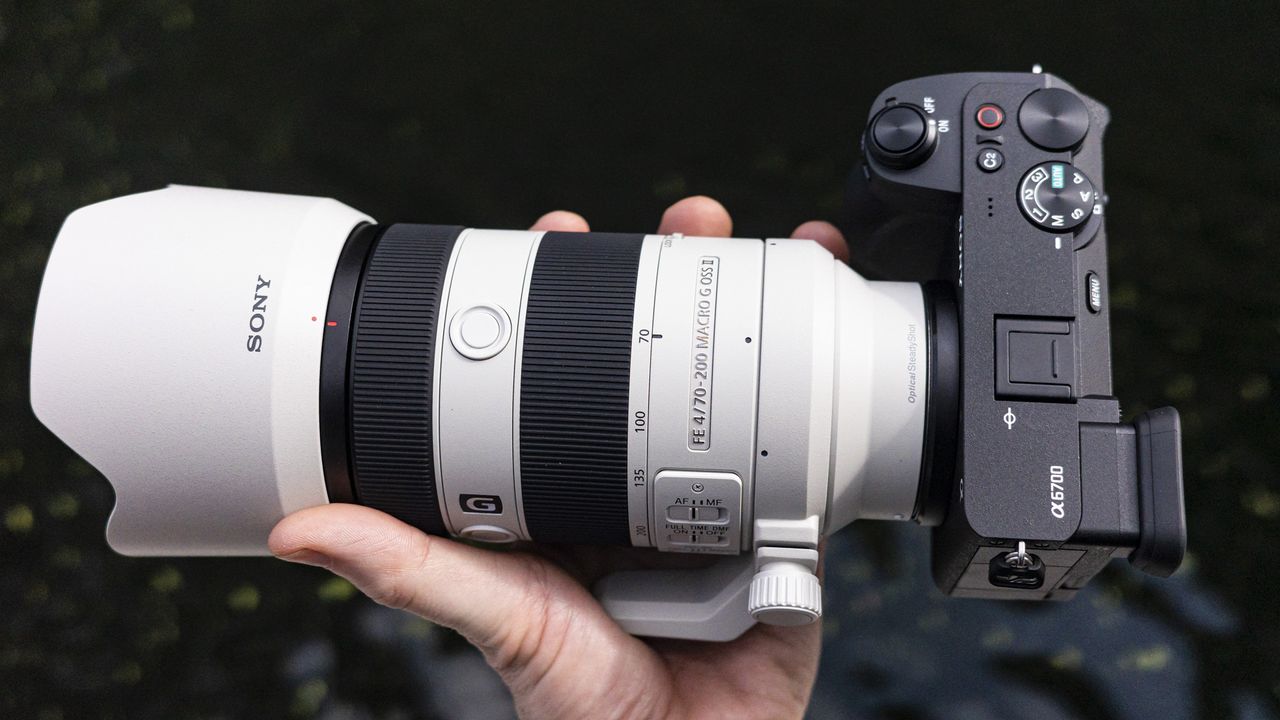 Sony FE 70-200mm F4 Macro G OSS II lens in the hand attached to Sony A6700