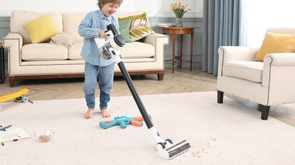 Image of Tineco Pure One S12 Cordless Stick Vacuum in promotional image being used to pick up mess