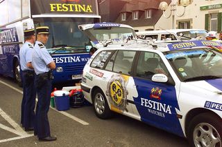 Two policemen stay next to a Festina teams car in Roscoffs harbor 14 July before the third stage of the 85th Tour de France between Roscoff and Lorient West of France The Festina team faces a doping scandal ELECTRONIC IMAGE AFP PHOTO Photo credit should read JOEL SAGETAFP via Getty Images