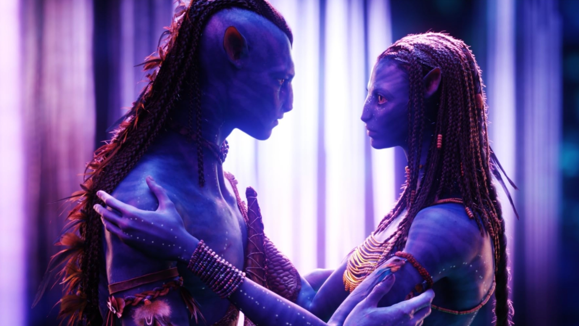 Two blue aliens with long hair, embracing each other. There is an ethereal purple and white light in the background.