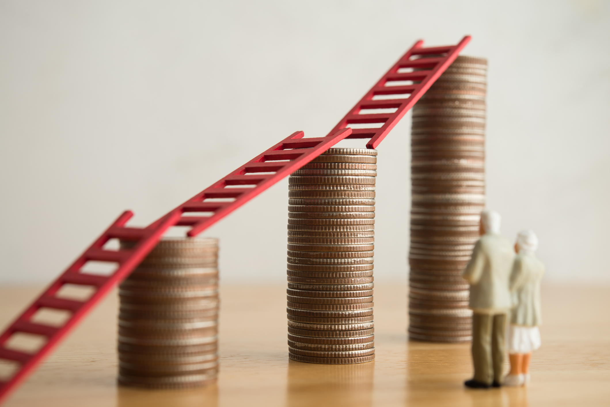 Old senior couple person looking at growth stack coins graph chart with red ladder.