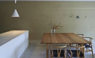 Large table & chairs in front of stone wall