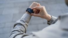 A man checks his smartwatch for the time.