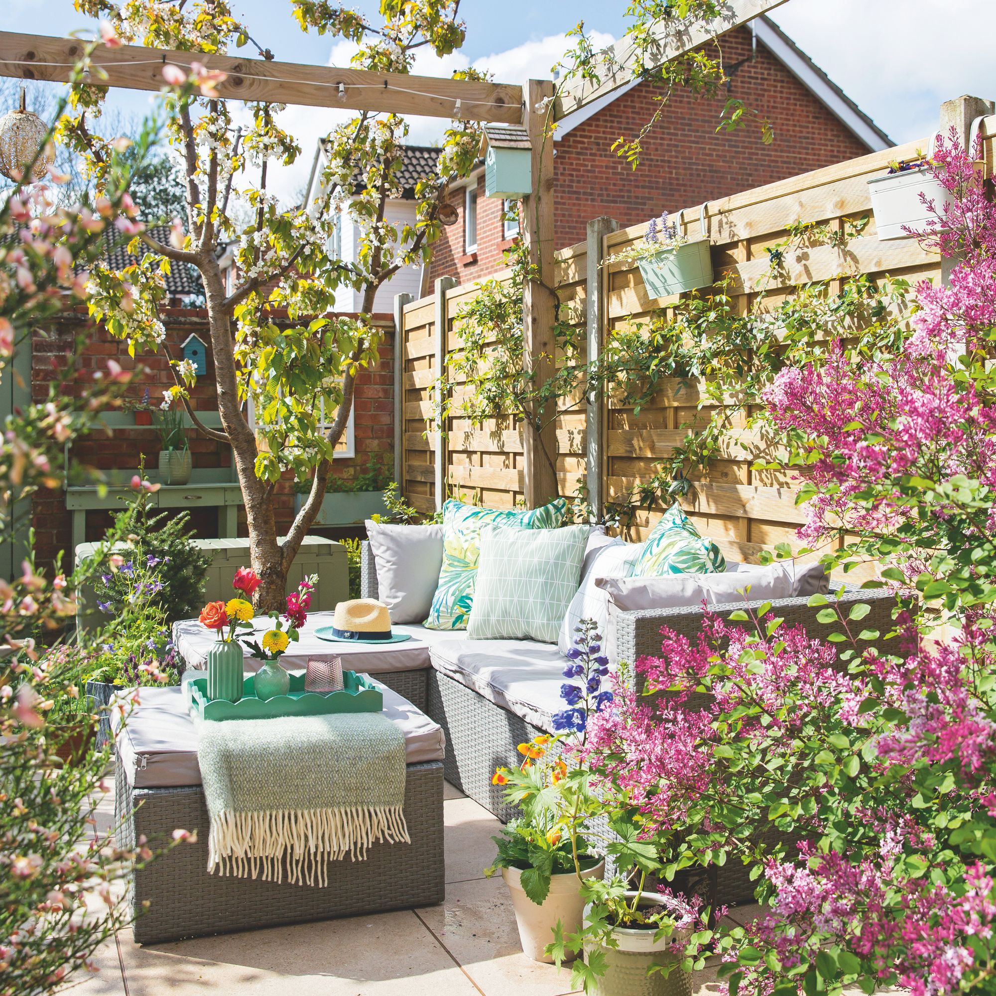 Patio area with garden furniture on it, surrounded by plants