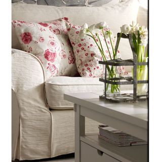 sofa set with printed red floral cushions and white wooden table