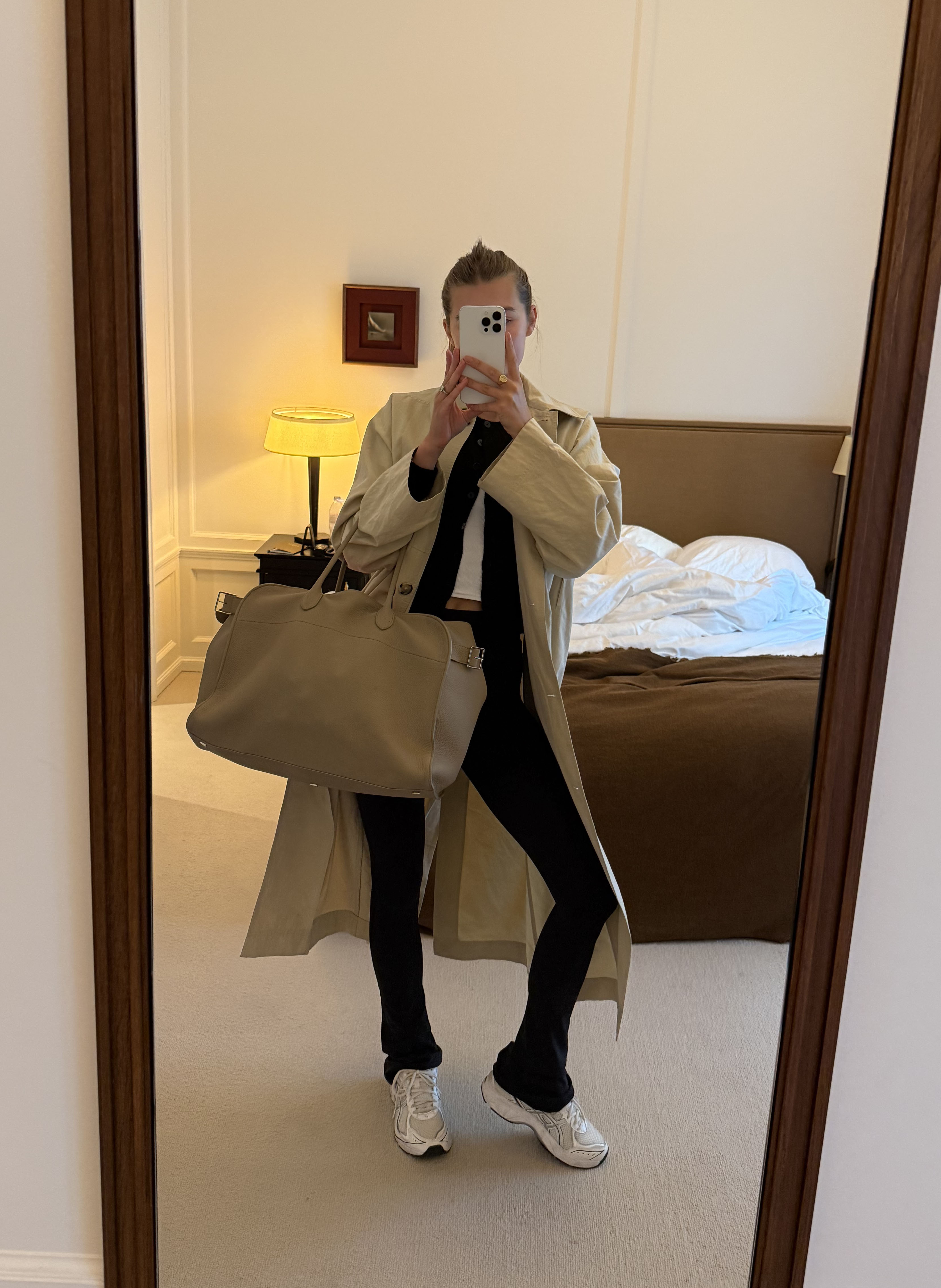 Sara Walker wearing a trench, sweater, and black pants.