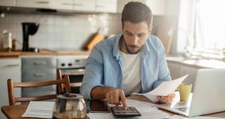 Man sitting in kitchen table working on his finances