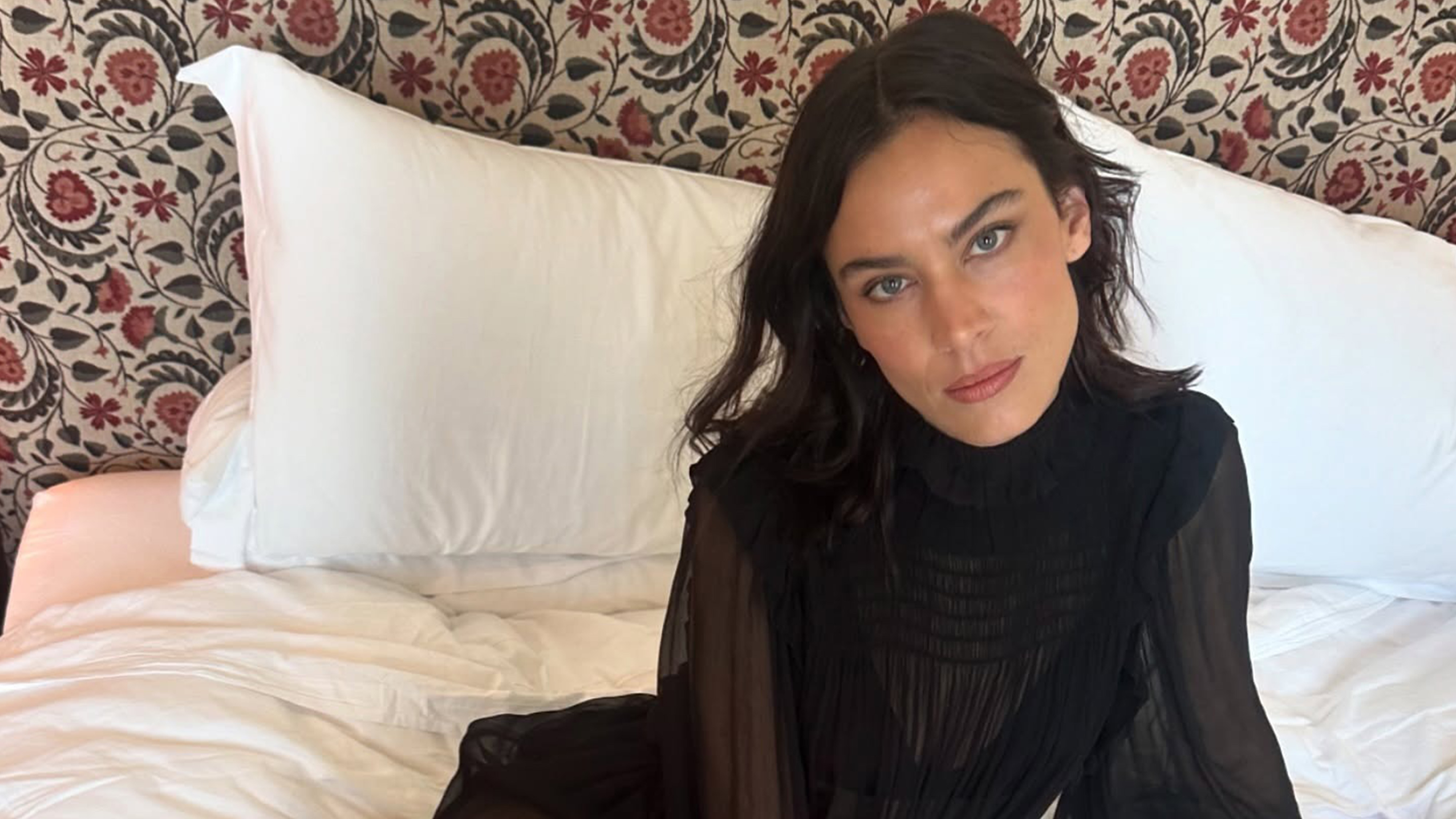 Alexa Chung wears a long-sleeve sheer black dress.