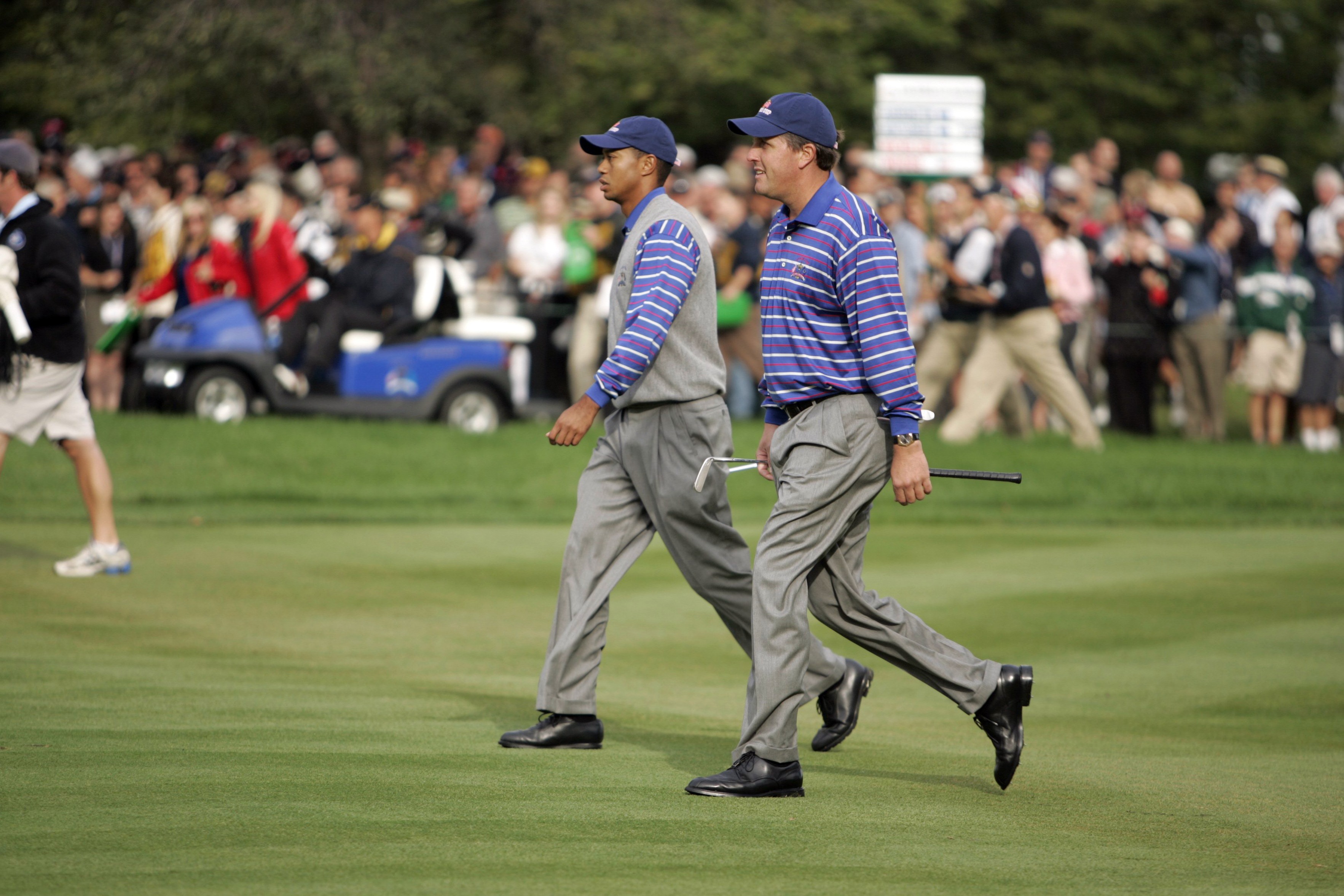 Tiger Woods and Phil Mickelson walk down the fairway