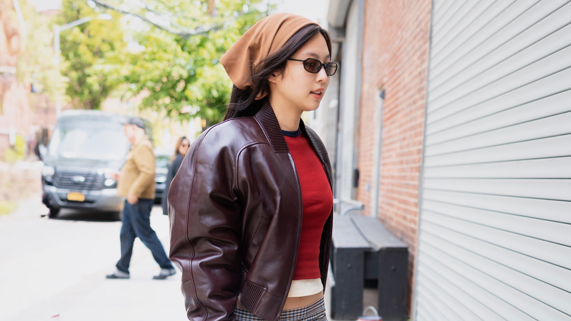Jennie Kim wearing a leather jacket, sheer midi skirt, and wedge-heel thong sandals in NYC.