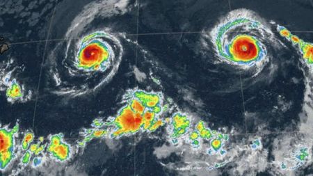 A radar weather map showing two hurricanes that look like the eyes in a multicolor smiley face