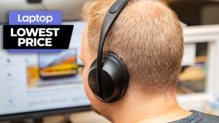 Bose 700 headphones in black colorway worn by man sitting at desk
