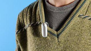 the plaud notepin, an AI dictaphone, in silver. it's a pill shaped device at just 2 inches long and can be worn as a watch, necklace, clip, or pin thanks to the magnetic panel