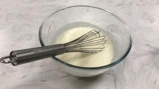 Vanilla ice cream mix in a bowl with a whisk