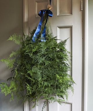 Door foliage swag tied with blue ribbon