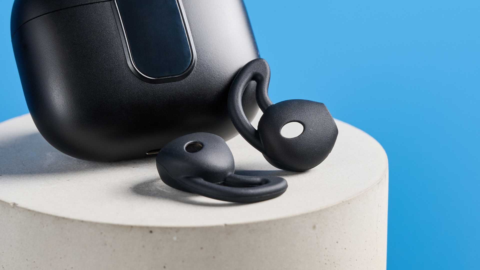 the h2o audio ript-lite earbuds in black and blue, photographed against a blue background, for both working out and everyday use