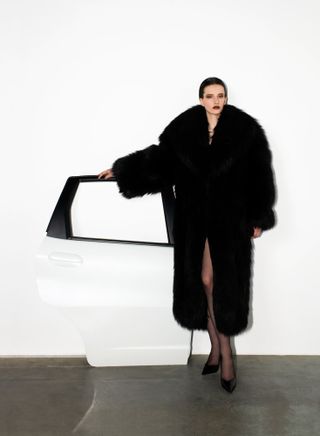 Model wears black coat by Saint Laurent by Anthony Vaccarello