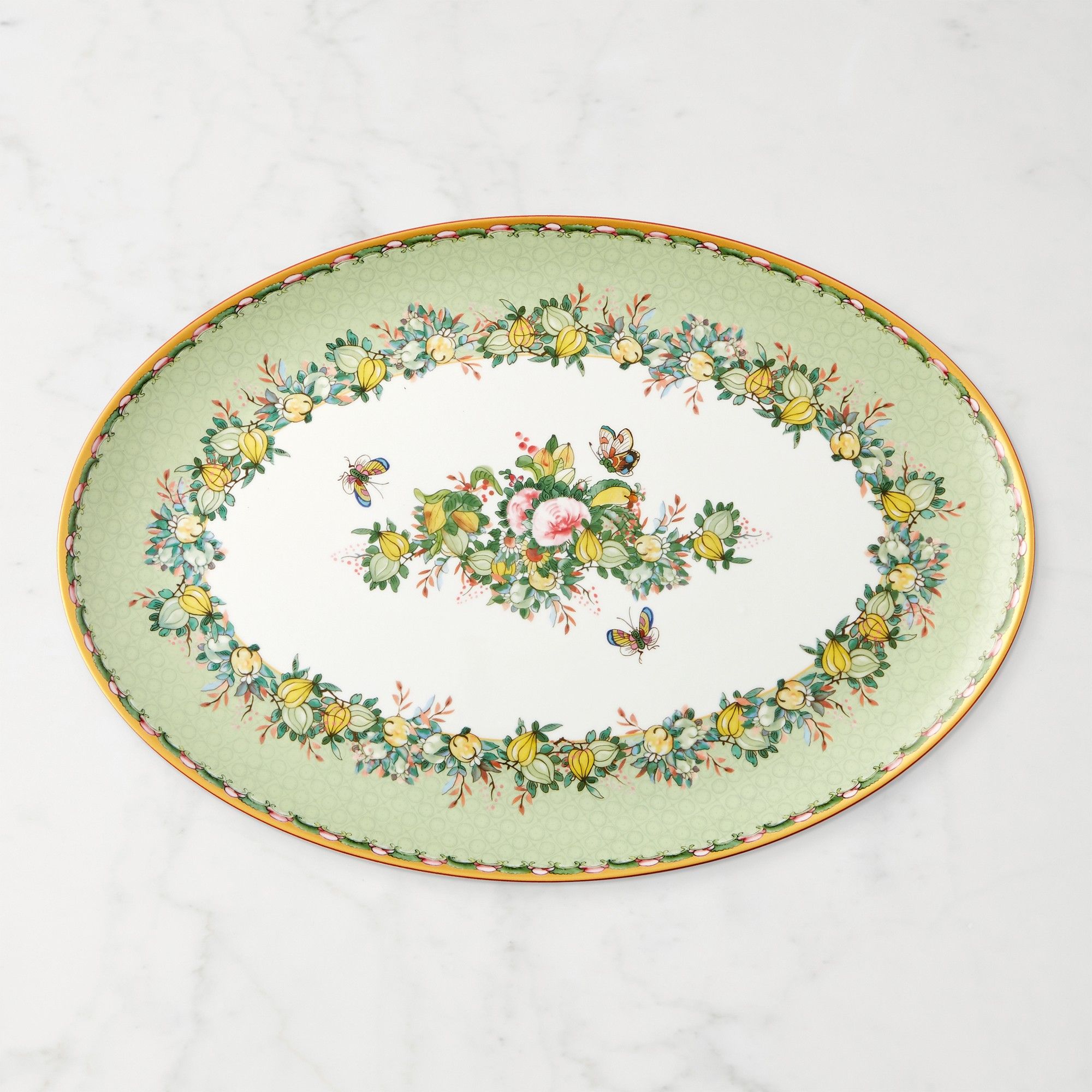Oval platter with green edges, intricate floral print, and yellow trim