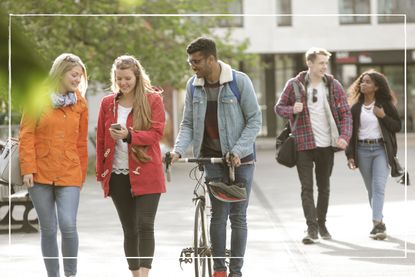 group of university students walking through town centre chatting to each other