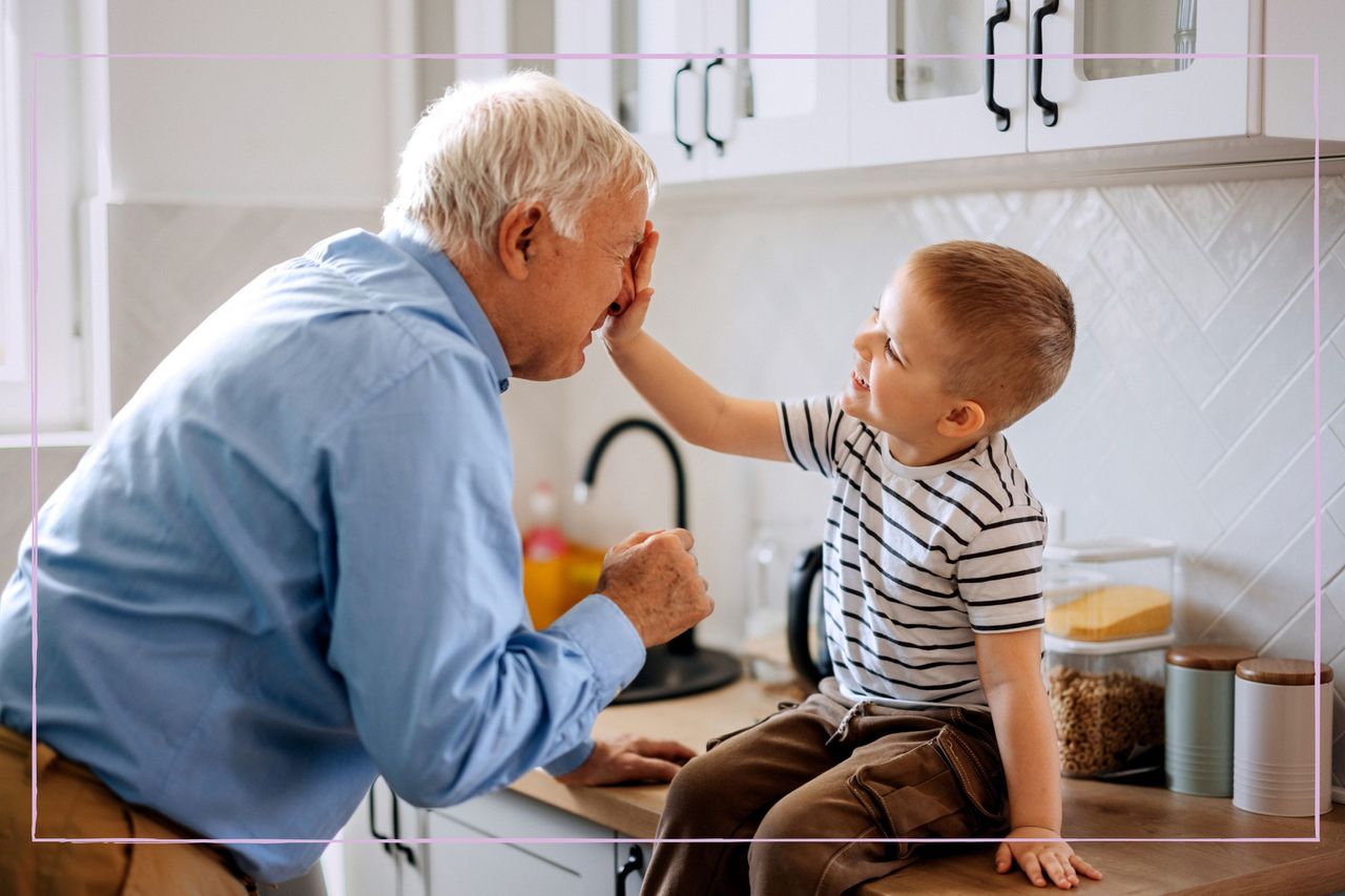 Little boy with his hand in his granddad&#039;s face